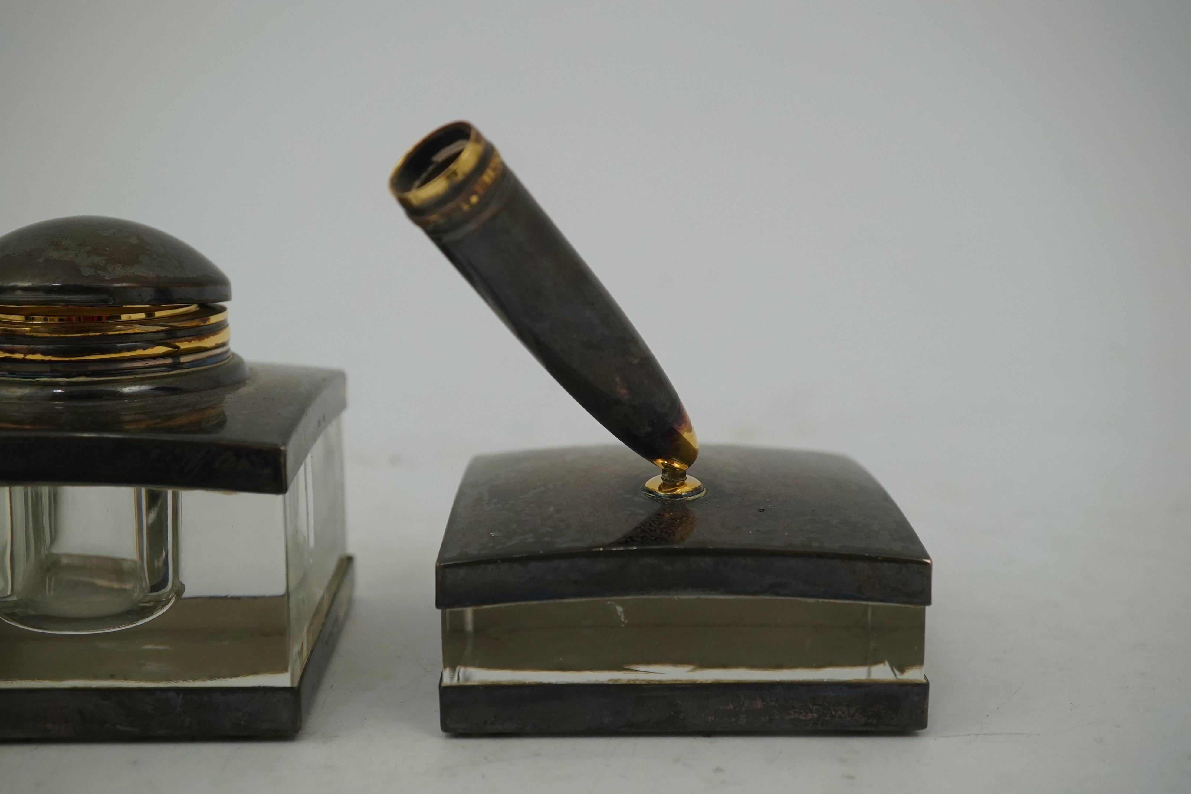 A Montblanc three piece German silver and glass desk set comprising pen stand, inkwell and blotter, each glass mounted, silver engraved with the Montblanc logo